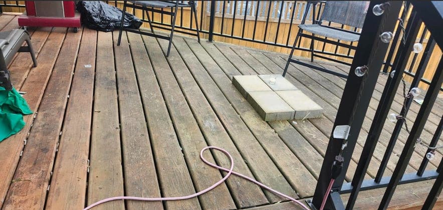 Deck before restoration: weathered grey boards with the finish worn off