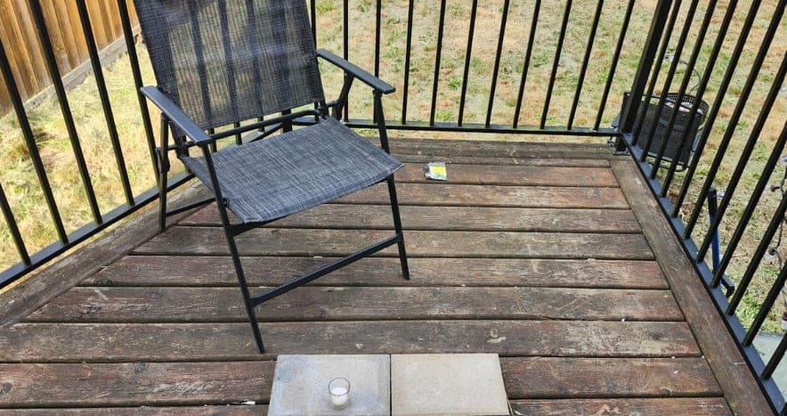 Deck before restoration: faded boards and a bare metal railing on the upper landing