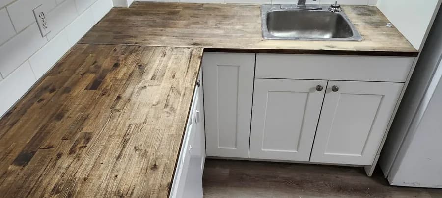 Kitchen before renovation: a scratched wood countertop and an old drop-in sink