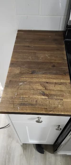 Kitchen before renovation: a worn countertop running along the base cabinets